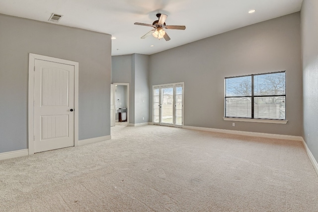 carpeted empty room featuring high vaulted ceiling and ceiling fan