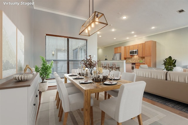 dining area featuring light colored carpet and crown molding