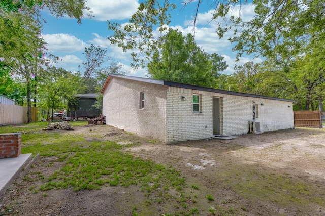 back of house featuring ac unit and fence