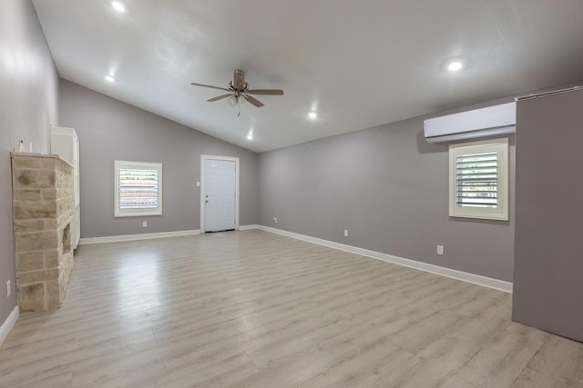 unfurnished living room featuring ceiling fan, baseboards, vaulted ceiling, a wall mounted AC, and light wood finished floors