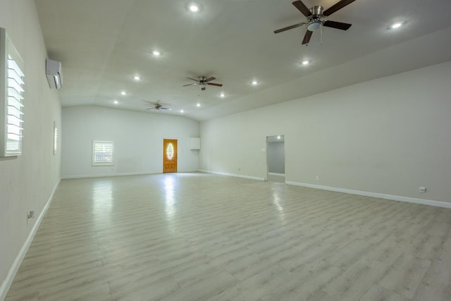 spare room featuring baseboards, a wall unit AC, light wood-style flooring, and recessed lighting