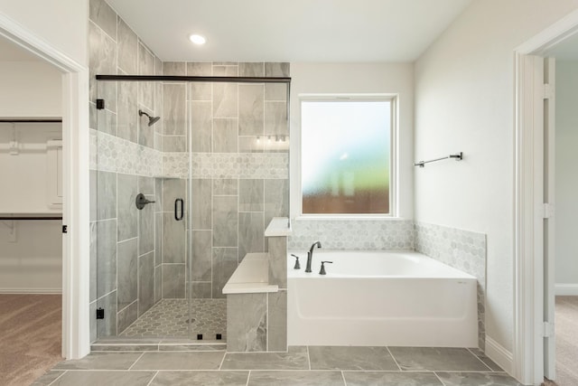 full bathroom with a garden tub, a shower stall, a spacious closet, and tile patterned flooring