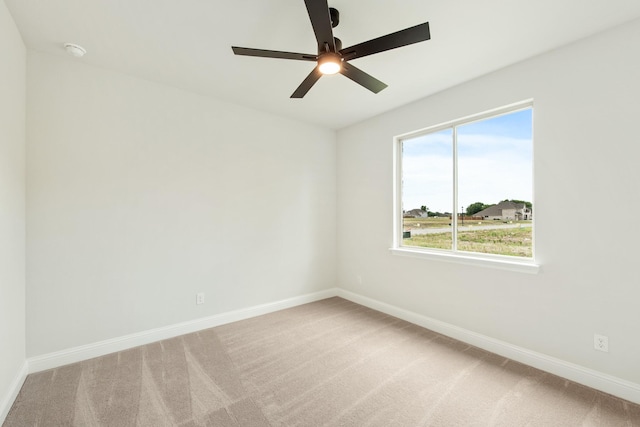 empty room featuring light carpet, ceiling fan, and baseboards