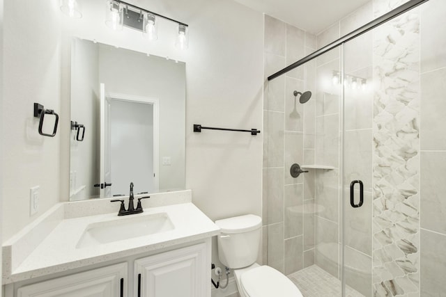 bathroom featuring vanity, a shower stall, and toilet