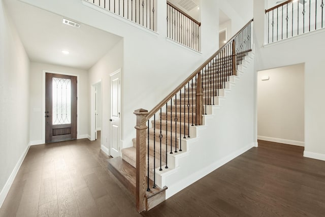 foyer featuring wood finished floors, visible vents, and baseboards