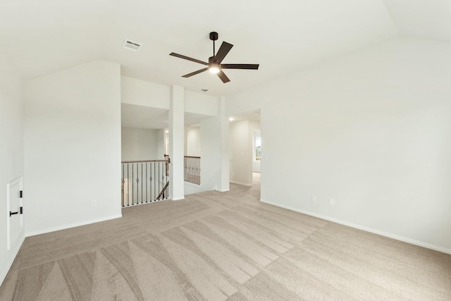 carpeted spare room with lofted ceiling, a ceiling fan, visible vents, and baseboards