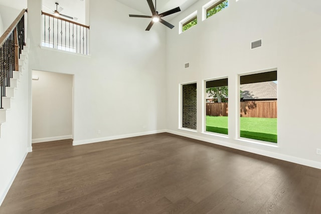 unfurnished living room with visible vents, baseboards, dark wood-style floors, ceiling fan, and stairway