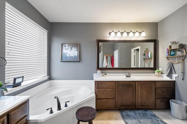 bathroom featuring tile patterned flooring, a bath, and vanity