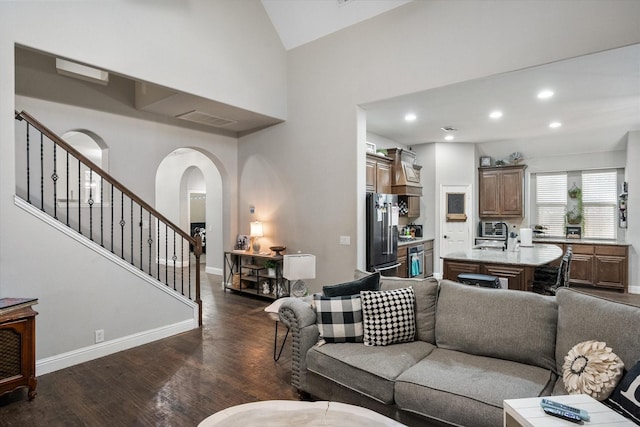 living room featuring dark hardwood / wood-style flooring and high vaulted ceiling