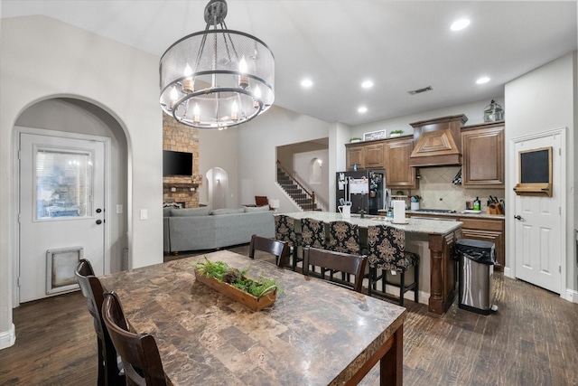 dining area with a fireplace, dark hardwood / wood-style flooring, and a notable chandelier