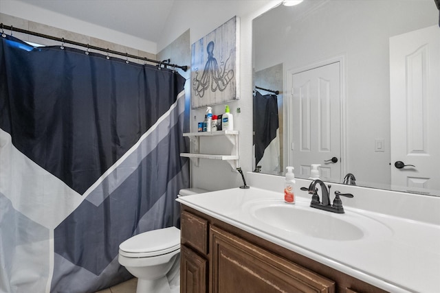 bathroom with tile patterned flooring, vanity, toilet, and vaulted ceiling