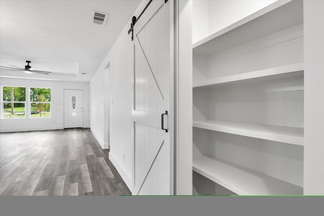 corridor featuring dark hardwood / wood-style flooring and a barn door