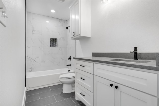 full bathroom featuring tile flooring, toilet, vanity, and tiled shower / bath