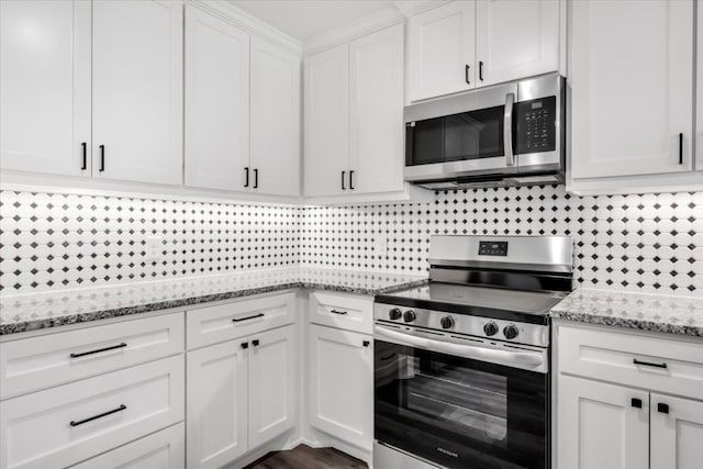 kitchen featuring appliances with stainless steel finishes, backsplash, light stone counters, and white cabinetry