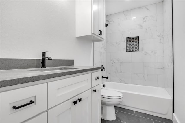 full bathroom with tile floors, toilet, tiled shower / bath combo, and vanity