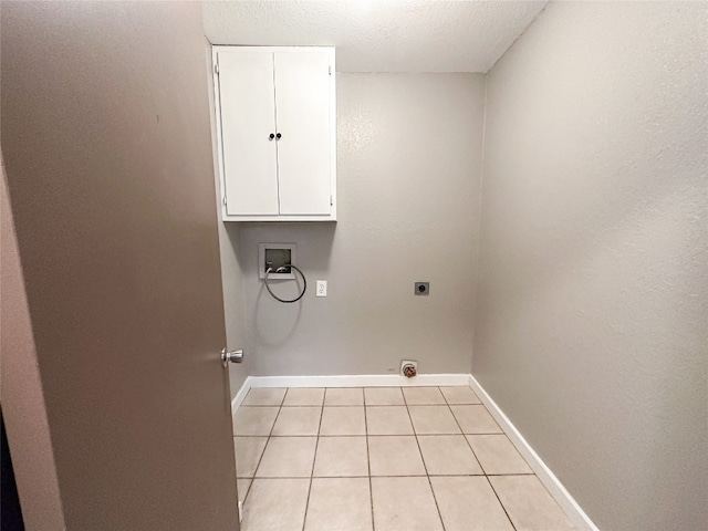 washroom featuring light tile floors, electric dryer hookup, washer hookup, a textured ceiling, and cabinets