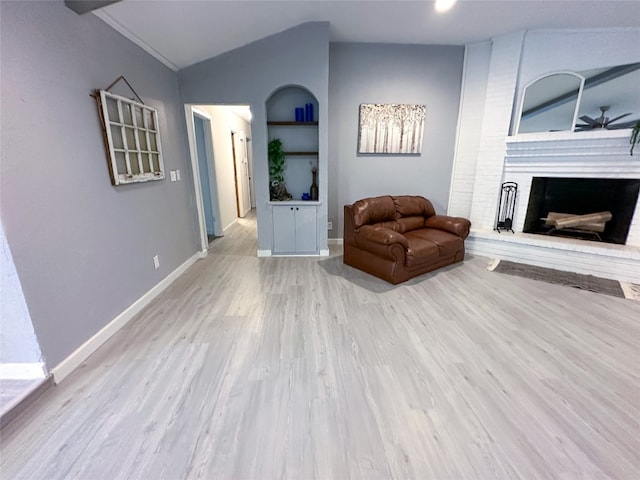 living room with a fireplace, lofted ceiling, light hardwood / wood-style flooring, and ceiling fan