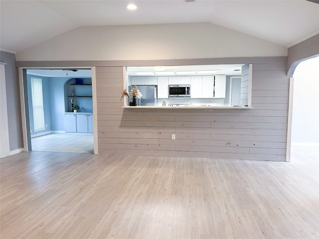 unfurnished living room with light hardwood / wood-style floors and lofted ceiling