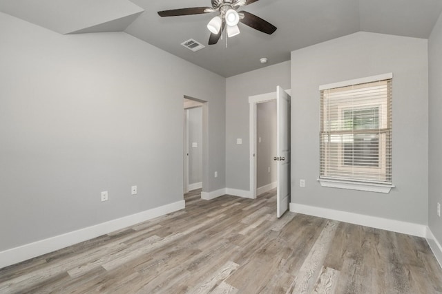 empty room featuring ceiling fan, lofted ceiling, and light hardwood / wood-style flooring