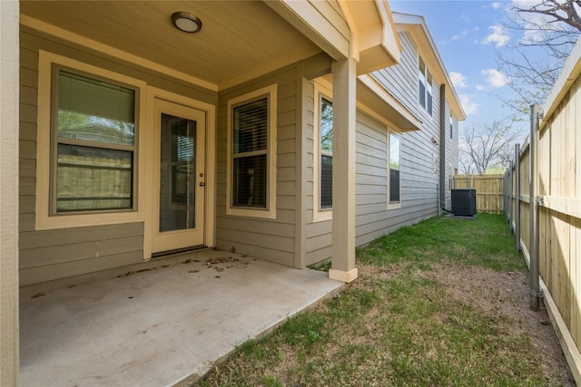 view of exterior entry with central AC unit and a patio area