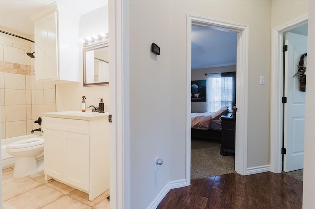 full bath with toilet, wood finished floors, vanity, baseboards, and shower / bathtub combination with curtain