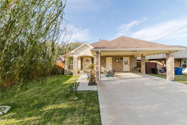 view of front facade with brick siding, fence, and a front yard