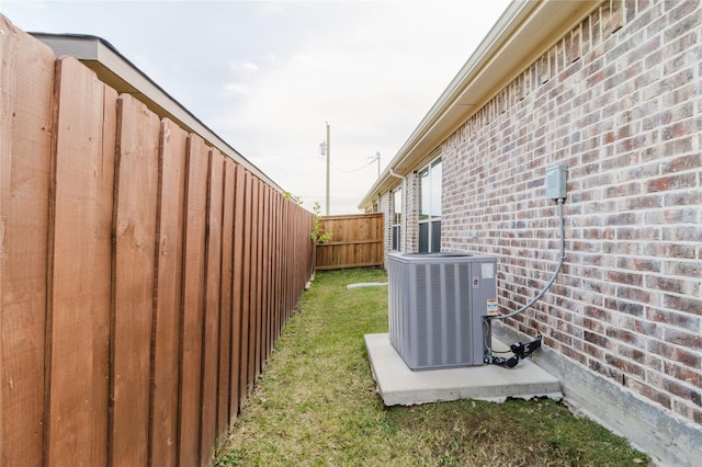 view of yard featuring fence and central AC unit