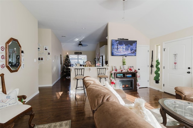 living room featuring dark hardwood / wood-style flooring, lofted ceiling, and a fireplace