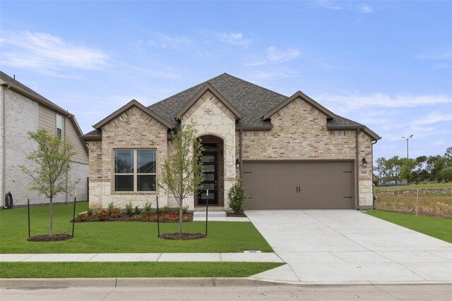 view of front of property with a garage and a front lawn