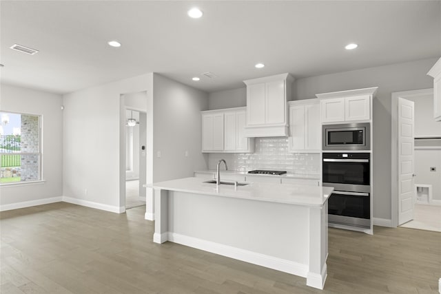 kitchen featuring white cabinetry, sink, an island with sink, and appliances with stainless steel finishes