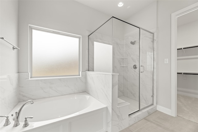 bathroom featuring shower with separate bathtub