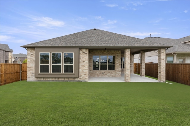 back of property with a lawn and a patio area