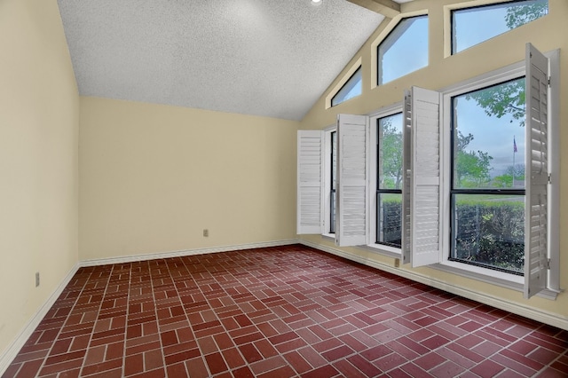 spare room featuring high vaulted ceiling and a textured ceiling