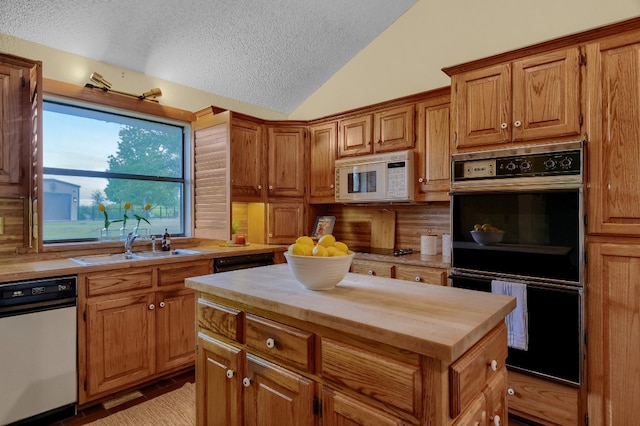 kitchen with a center island, wood counters, vaulted ceiling, white appliances, and a textured ceiling