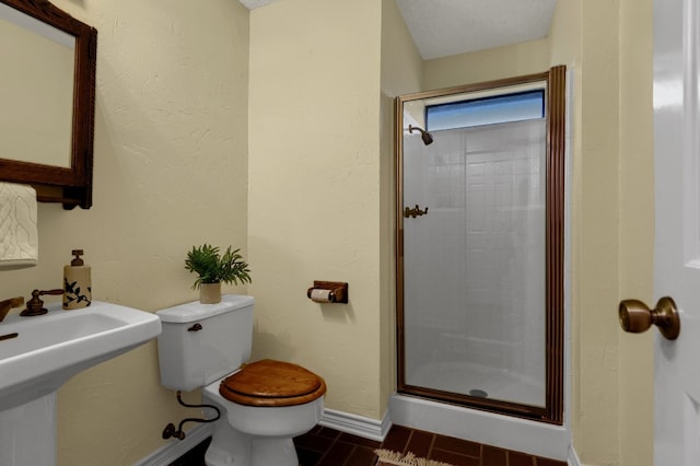 bathroom featuring walk in shower, toilet, and a textured ceiling