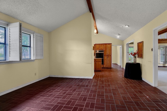 kitchen with double oven, vaulted ceiling, and a textured ceiling