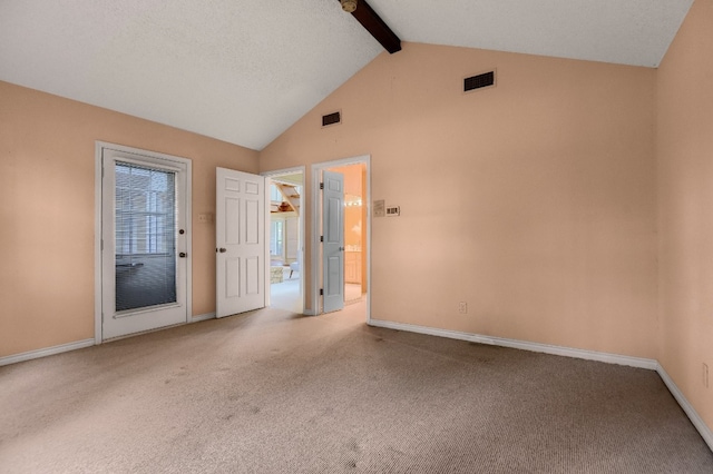 carpeted empty room with lofted ceiling with beams