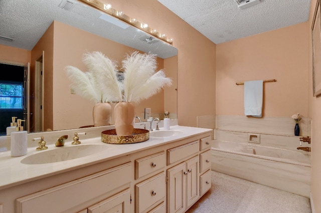 bathroom featuring a washtub, a textured ceiling, and vanity