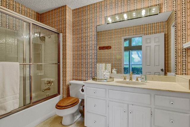 full bathroom with toilet, bath / shower combo with glass door, a textured ceiling, and vanity