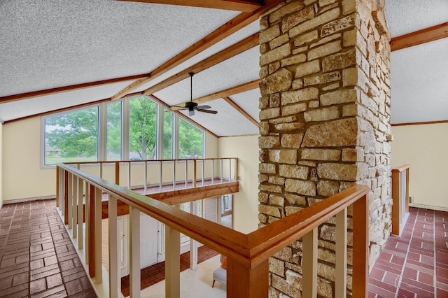 hall featuring a textured ceiling and vaulted ceiling with beams