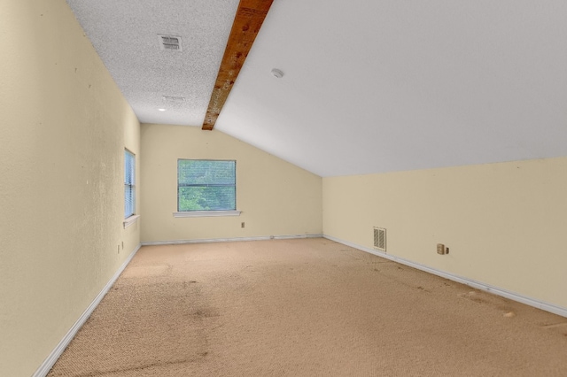 additional living space featuring a textured ceiling, carpet floors, and vaulted ceiling with beams