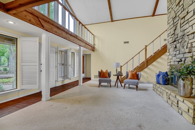 foyer entrance featuring carpet flooring, beamed ceiling, and high vaulted ceiling