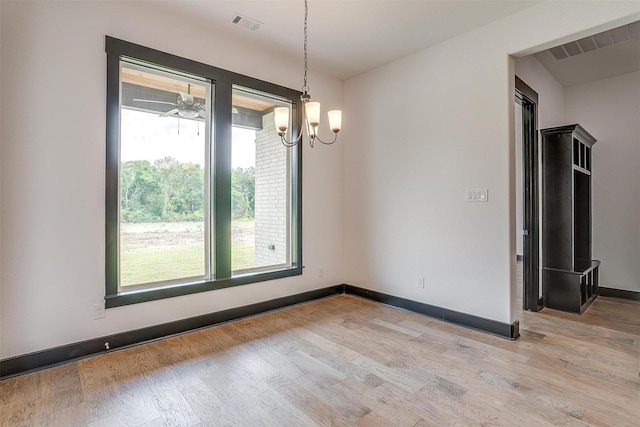 unfurnished room featuring light wood-type flooring, visible vents, and baseboards