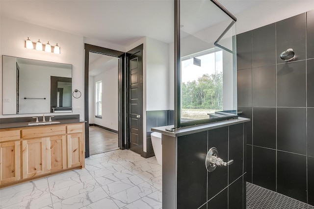 full bath with a walk in shower, marble finish floor, and vanity