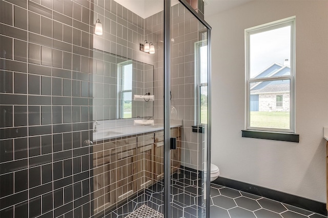 full bathroom featuring vanity, tiled shower, tile patterned flooring, and toilet