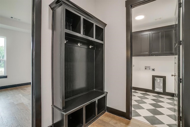 mudroom with light floors, visible vents, and baseboards