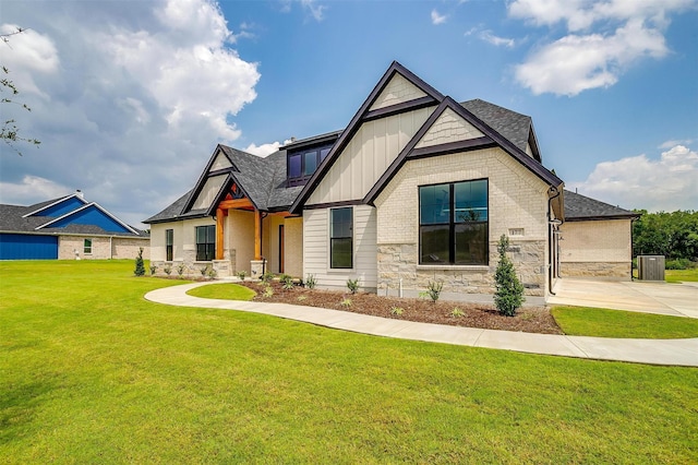 view of front of home with roof with shingles, brick siding, board and batten siding, stone siding, and a front lawn