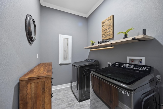 laundry room featuring washing machine and clothes dryer and crown molding