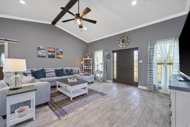 living room featuring ornamental molding, a barn door, light hardwood / wood-style flooring, and a healthy amount of sunlight