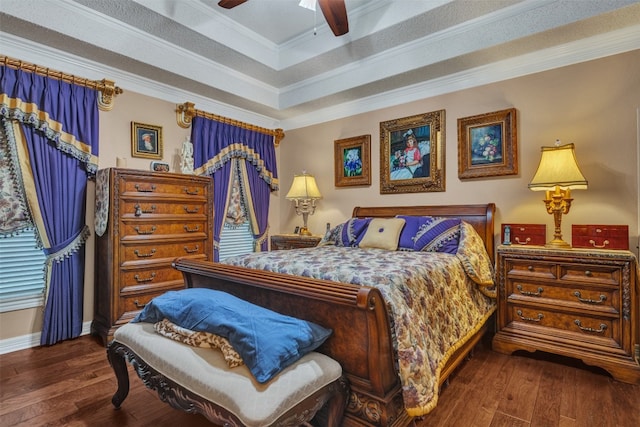 bedroom featuring ornamental molding, ceiling fan, a tray ceiling, and dark hardwood / wood-style floors